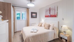 A neatly arranged bedroom with a bed, bedside table, and a wall-mounted artwork. - Villa Muñoz Ronda by Ruralidays (Málaga)