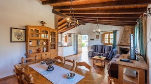 Cozy living area with a high ceiling, wooden beams, and a fireplace.