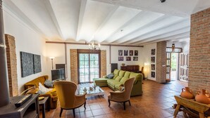 A spacious living room with a green sofa, two armchairs, a coffee table, and a fireplace. - Caserío Lo Bulle Oria by Ruralidays (Almería)