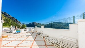 A rooftop terrace with white benches, a pool, and a view of mountains. - La Mina Benaoján by Ruralidays (Málaga)