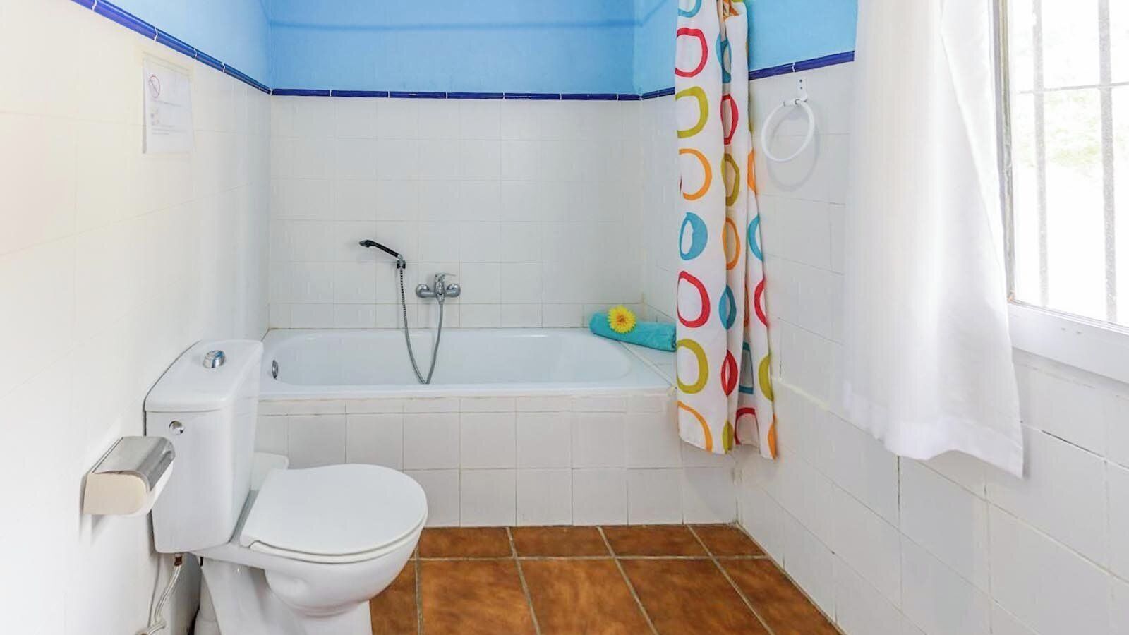 Une salle de bain équipée de toilettes, d’une baignoire et d’une douche.