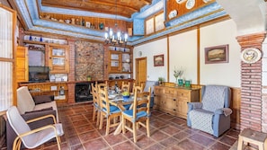 Una sala de estar acogedora con chimenea, muebles de madera y comedor.