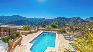 A swimming pool with a view of mountains, a fenced patio area, and a small garden. - El Algarrobo de Alora Álora by Ruralidays (Málaga)