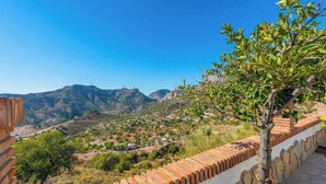 A view of a mountainous landscape with terraced fields and a brick wall. - El Algarrobo de Alora Álora by Ruralidays (Málaga)