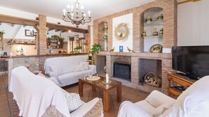 Un salón acogedor con chimenea, asientos cómodos y una televisión.