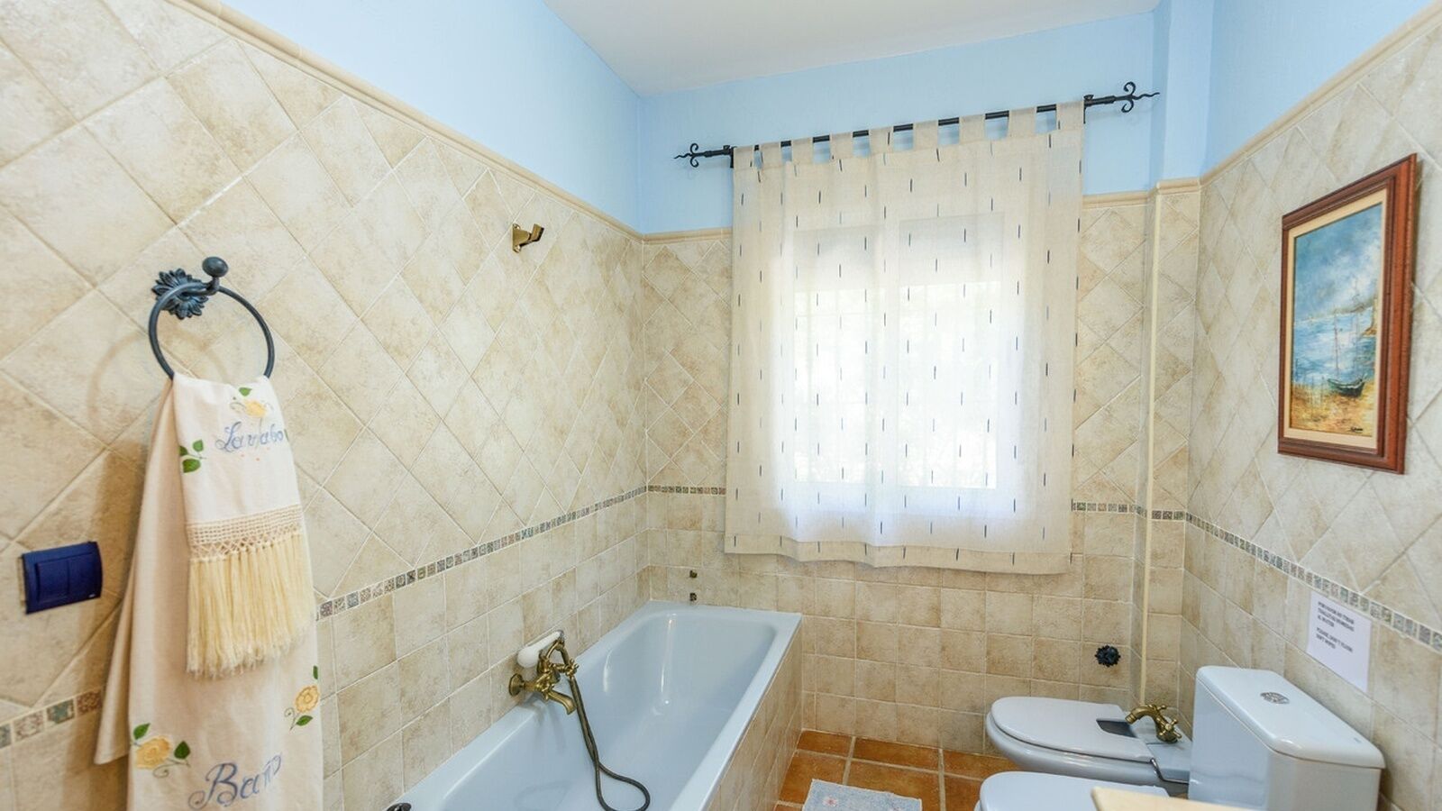 Un baño con bañera, inodoro y cortina de ducha.