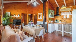 A cozy wooden interior with a dining area, kitchen, and living space. - Hornillos Alozaina by Ruralidays (Málaga)