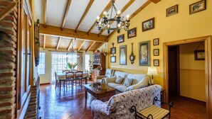 A spacious living area with a dining table, sofas, and a chandelier. - Villa Jiminez - A104 Coín by Ruralidays (Málaga)