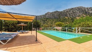 A swimming pool with a surrounding deck, lounge chairs, and a mountain backdrop. - Bodega Ciprés Benaoján by Ruralidays (Málaga)