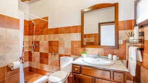 Une salle de bain équipée d’une douche, de toilettes, d’un lavabo et d’un meuble-lavabo.