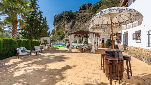 A patio area with outdoor seating, a pergola, and a pool. - Iratxe Montefrío by Ruralidays (Granada)