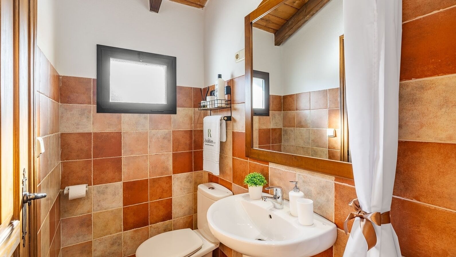 Ein Badezimmer mit Toilette, Waschbecken und Spiegel.