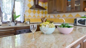 Eine Küchenarbeitsplatte mit zwei Weingläsern, einer Schüssel mit Trauben und einer Schüssel mit Limetten.