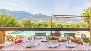 Eettafel voor twee met uitzicht op bergen en een zwembad.