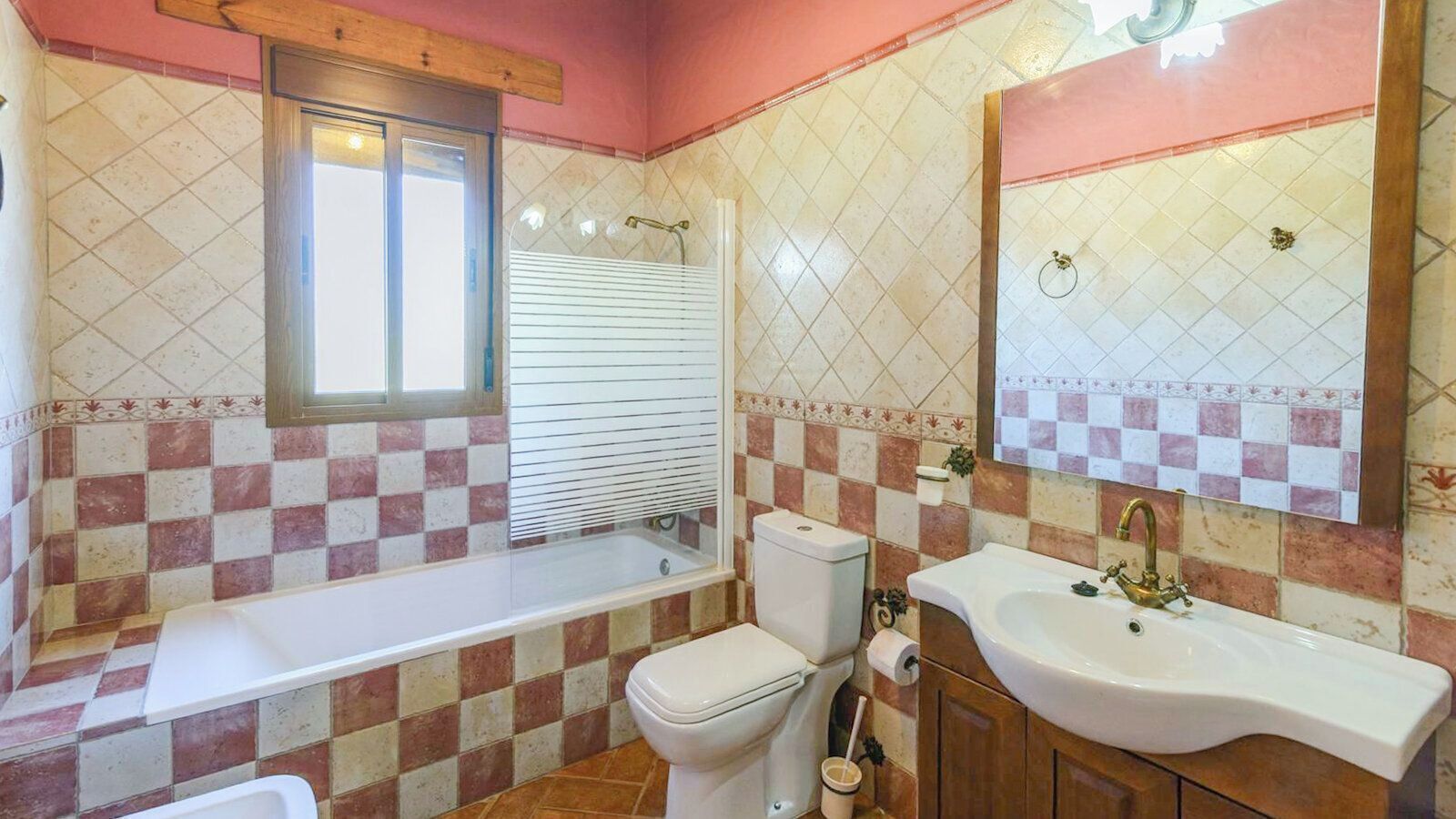 Casa de banho com banheira, sanita e lavatório.
