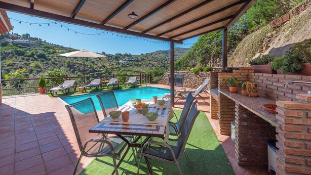 A covered outdoor area with a pool, dining table, chairs, and a barbecue grill. - Casa Amelia Cómpeta by Ruralidays (Málaga)