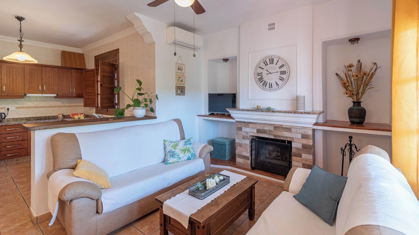 A living room with a fireplace, two sofas, a coffee table, and a TV.