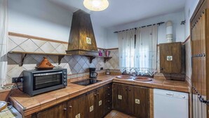 A compact kitchen with a built-in oven, a coffee maker, and a dishwasher.