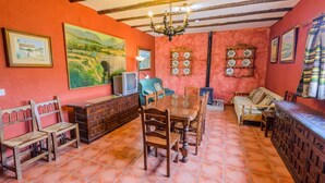 Un comedor con mesa y sillas de madera, un sofá y un televisor.