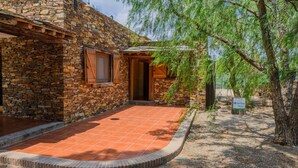 A rustic stone building with a tiled entrance and a wooden door. - Los Albardinales - Casa Picual Tabernas by Ruralidays (Almería)