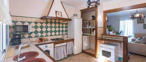 A compact kitchen with a microwave, sink, and a small dining area.