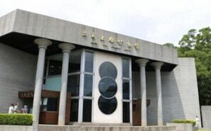 A modern building with a large entrance, columns, and a distinctive circular design on the facade.