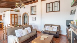 Una sala de estar acogedora con dos sofás, una mesa de centro de madera y una chimenea.