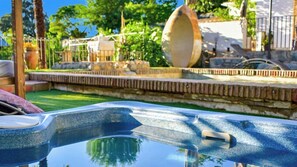 A swimming pool with a stone border and a large decorative bowl.