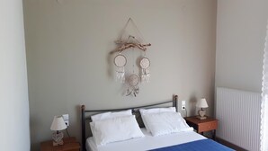 Un dormitorio con una cama, dos mesitas de noche y un adorno en la pared.
