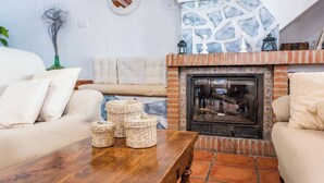 Uma sala de estar acolhedora com lareira, um sofá e uma mesa de centro com cestos.