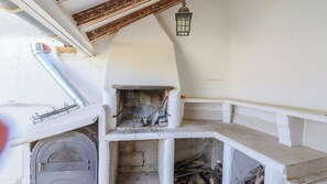 A rustic outdoor kitchen with a stone oven, wooden beams, and a lantern. - Casa Rural Pelijas Fontanar by Ruralidays (Jaén)