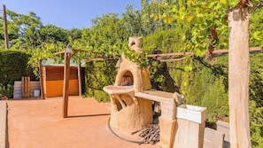 A rustic outdoor setting with a wooden structure, possibly a wine press, surrounded by greenery and a clear sky. - Casa Rural Pelijas Fontanar by Ruralidays (Jaén)