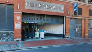 A building with a sign reading "THE ROCKWELL" and a maximum height sign of 2100. - Rockwell Waterkant Pad Prestwich (Cape Town)