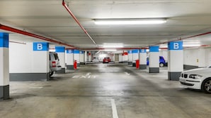 A multi-level parking garage with clearly marked exit signs and designated parking spaces. - Rockwell Waterkant Pad Prestwich (Cape Town)