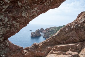 A rugged coastal landscape with a prominent rock formation and a clear view of the sea. - La Garrinière (Saint-Raphael)