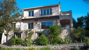 A two-story stone building with a tiled roof, multiple windows, and a balcony with wrought iron railings. - La Garrinière (Saint-Raphael)