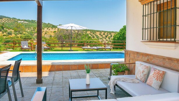 A poolside area with a sofa, chairs, and a table. - Huerta Alejo Alozaina by Ruralidays (Málaga)