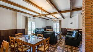 Un coin repas avec une table et des chaises en bois, un canapé et une cheminée.