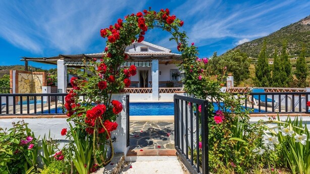 A villa with a pool, surrounded by lush greenery and a clear blue sky. - Cortijo Los Naranjos Frigiliana by Ruralidays (Málaga)