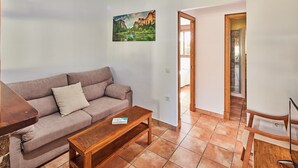 Un salon avec un canapé, une table basse en bois et un tableau accroché au mur.
