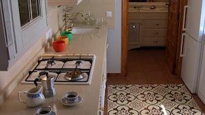 A kitchen with a gas stove, a sink, and a mirror.