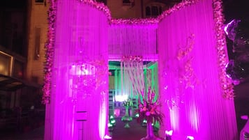 A decorated entrance with draped fabric and floral arrangements.