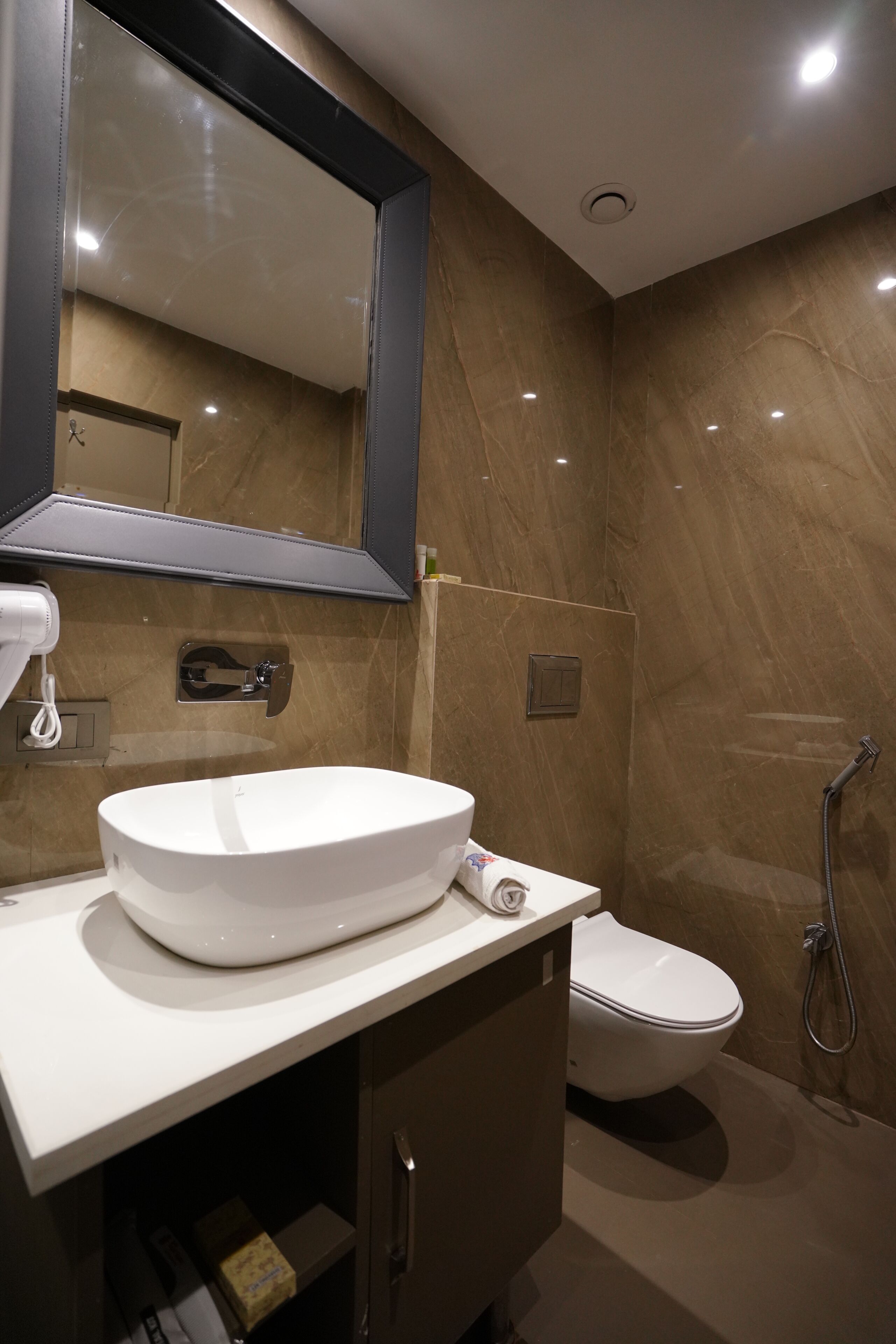 Un baño con lavamanos blanco, inodoro, espejo y ducha.