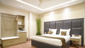 Un dormitorio moderno con una cama grande, mesitas de noche, un armario y una planta.
