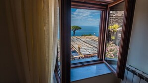 A room with a view of a garden and the sea through an open window. - Agriturismo Il Giardino di Vigliano (Massa Lubrense)