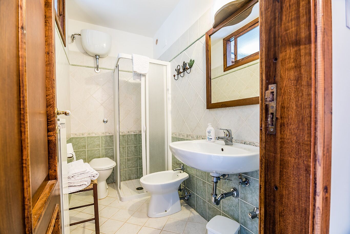 Un baño con ducha, inodoro, bidé, lavabo y espejo.