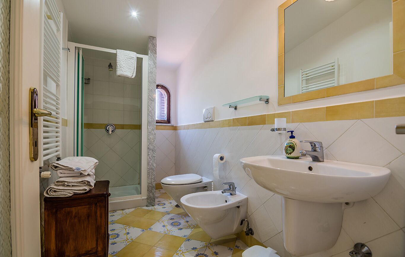 Un baño con ducha, inodoro, bidé y lavabo.