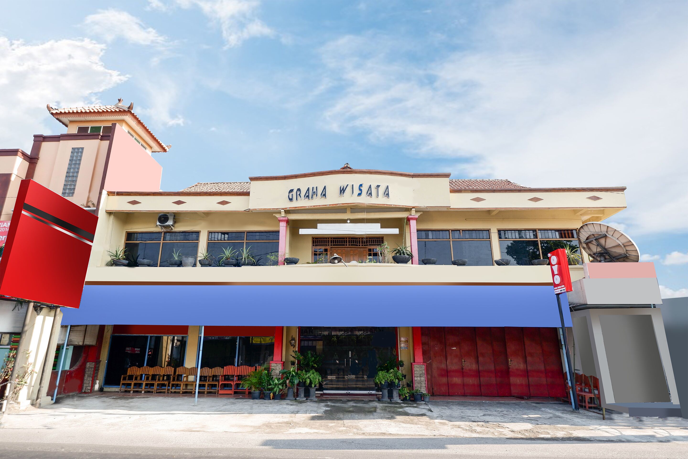 A two-story building with a sign reading "GRAMA WISATA" and a red door.
