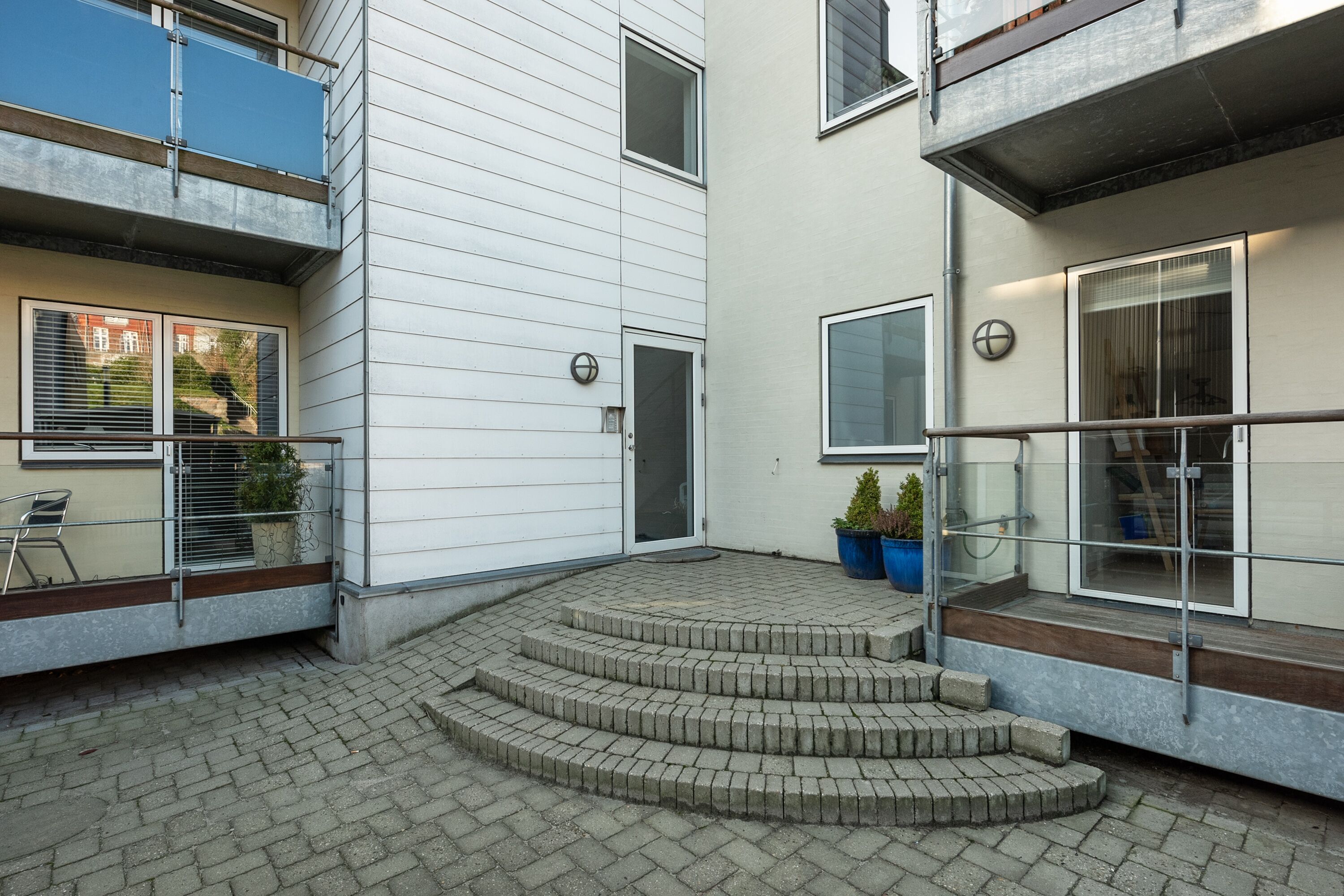 A modern building with a brick staircase leading to a balcony.