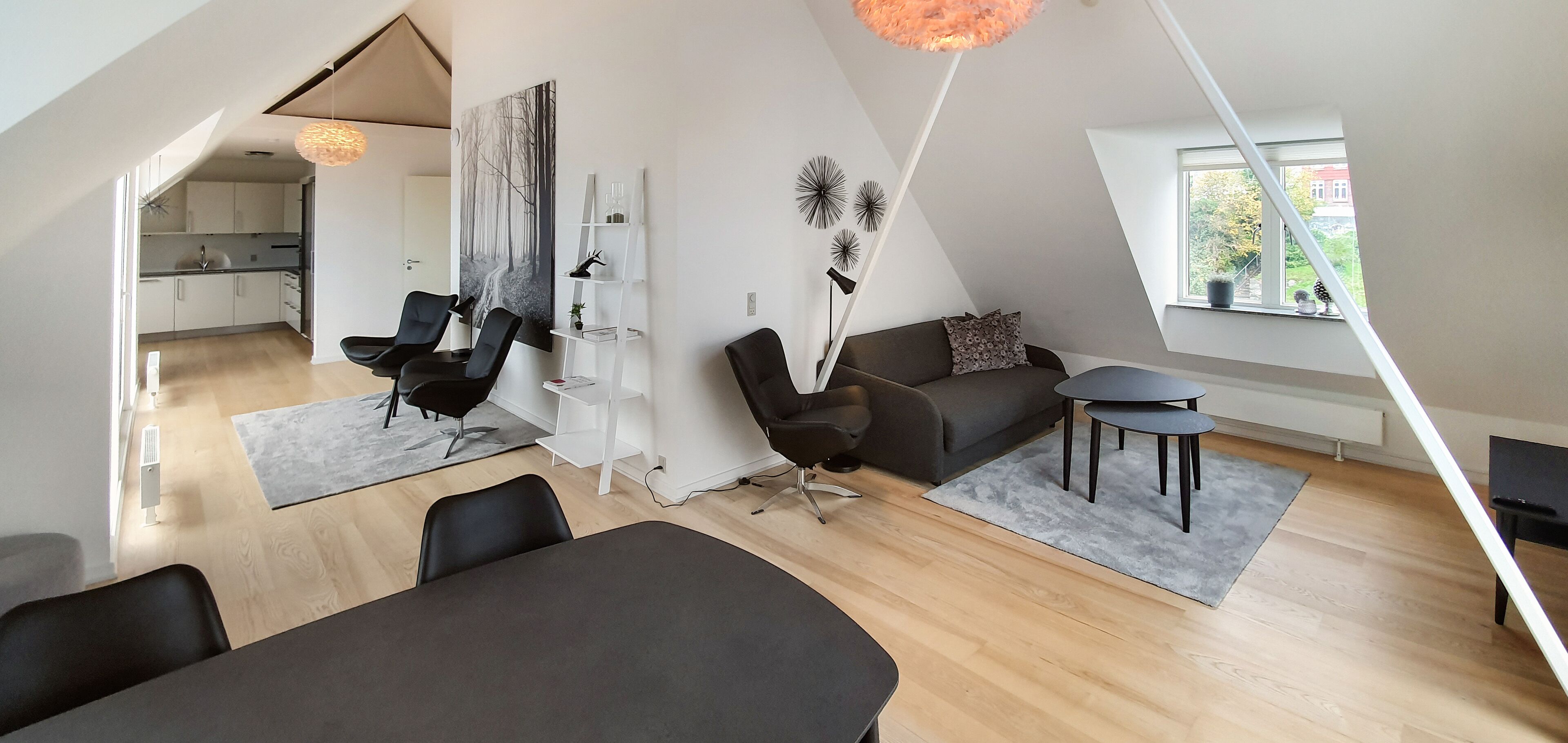 A modern loft apartment with a dining area, seating, and a kitchen.